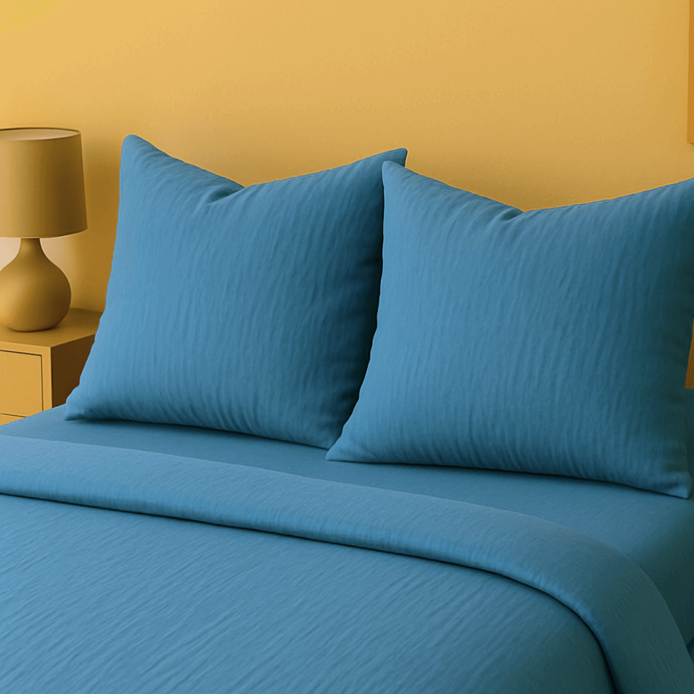 Taies d'oreillers bleu assorties à la  housse de couette zippée facile à mettre gaze de coton modèle DALLAS, couleur denim, sur lit avec oreillers.