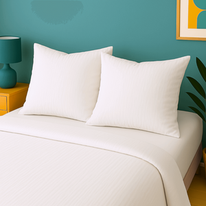 Taies d'oreillers en gaze de coton blanche houz'bed sur un lit aux couleurs modernes.