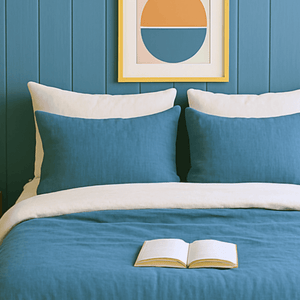 Taies d'oreillers bicolores bleu et blanche assorties à la housse de couette zippée facile à mettre gaze de coton modèle SANTORIN avec oreillers sur un lit contemporain. 